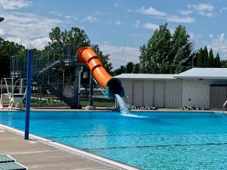 Orange water slide emptying into the Mora Aquatic Center pool